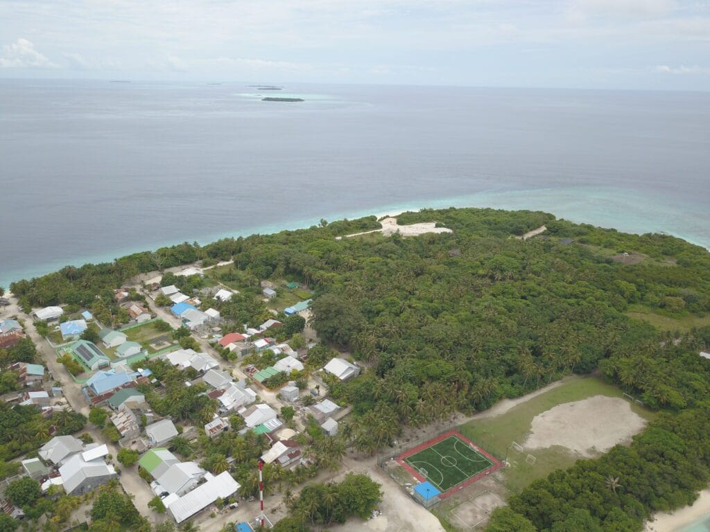 Aerial view of Fodhdhoo's local village and untouched uninhabited area, showcasing its natural beauty.