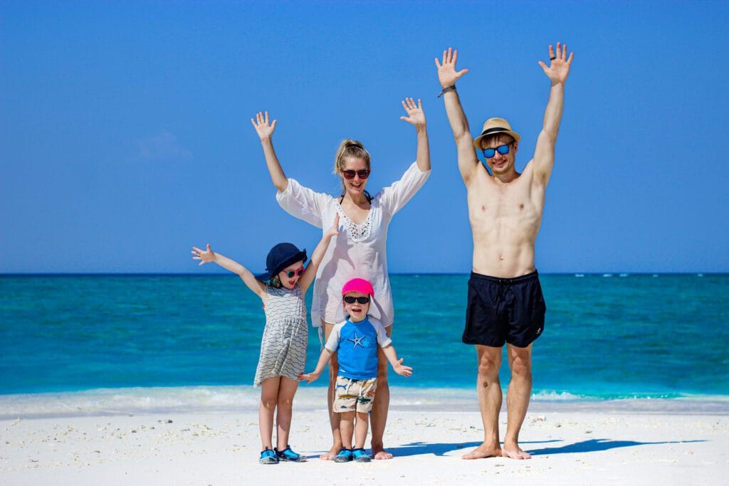 A family enjoying a budget-friendly beach day on Fodhdhoo Island, Maldives, with clear waters and a relaxing atmosphere.