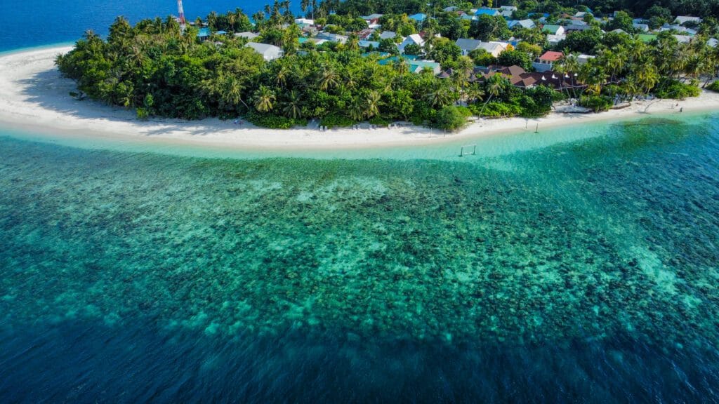 Aerial view of Fodhdhoo Beach with the turquoise ocean, ideal for a peaceful vacation at Maldives.