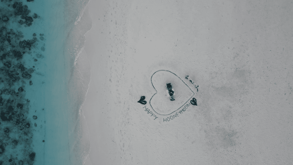 Aerial view of a romantic beach dinner setup at sunset during an adventure in Maldives Islands.