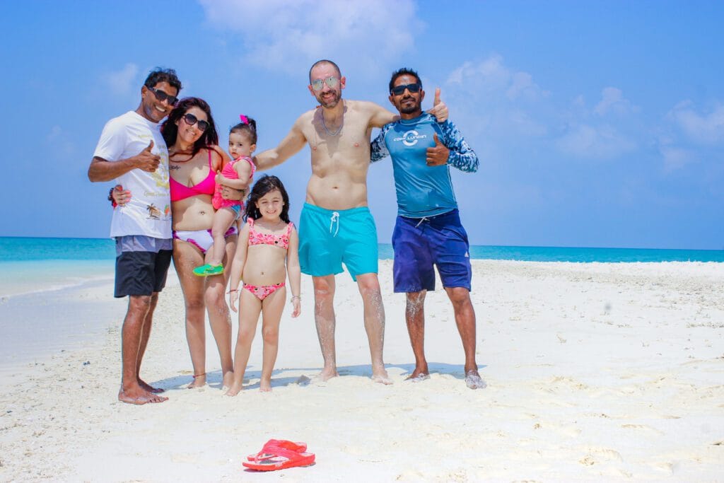 Family enjoying beach games on the sandy shores of Fodhdhoo’s nearby sandbank.