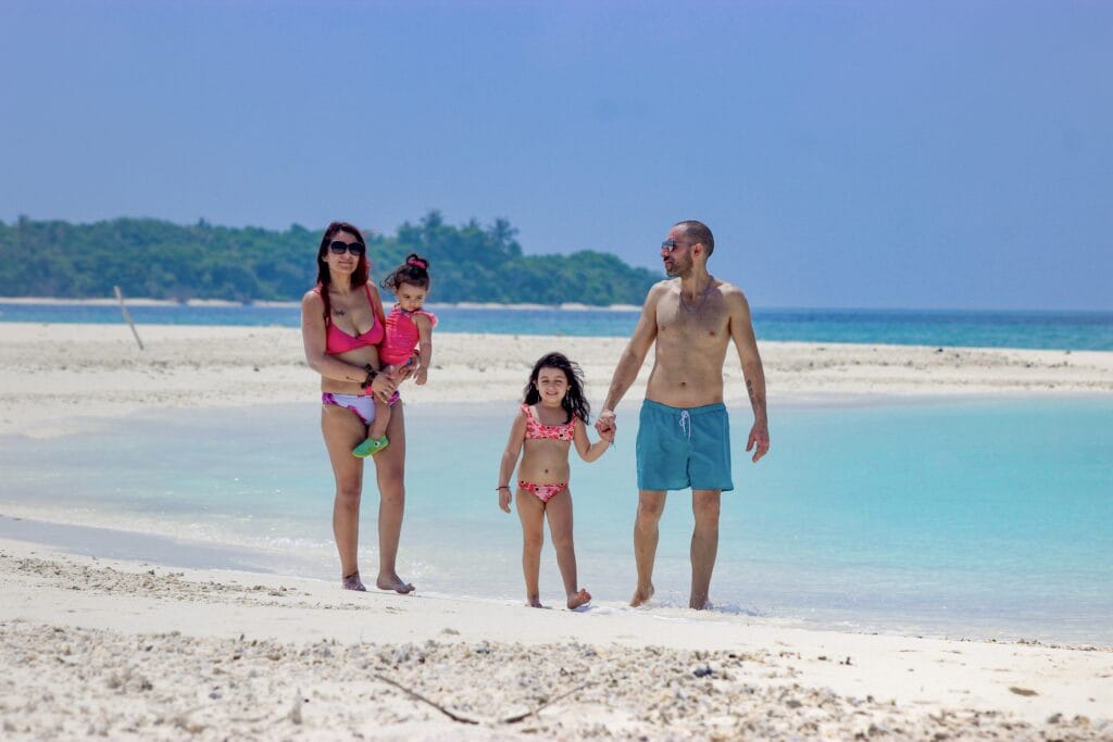 Family enjoying beach games on the sandy shores of Fodhdhoo’s nearby sandbank.