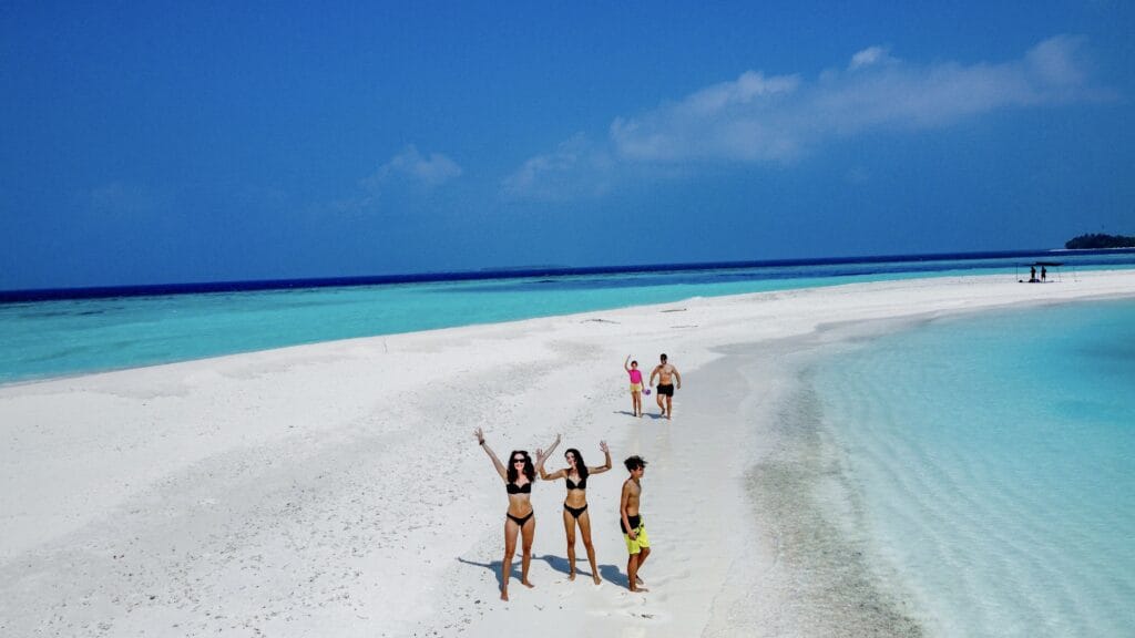 Family enjoying beach games on the sandy shores of Fodhdhoo’s nearby sandbank.