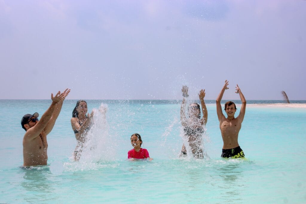 Family enjoying beach games on the sandy shores of Fodhdhoo’s nearby sandbank.