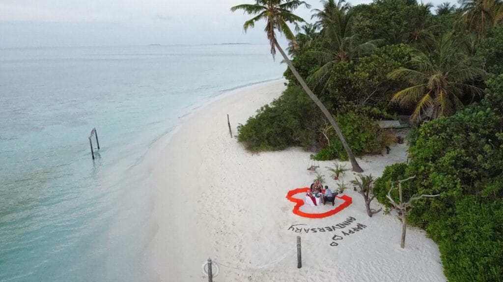 Aerial view of a private beach dinner setup at Sabba Beach Hotels, offering a romantic Maldives island retreat.