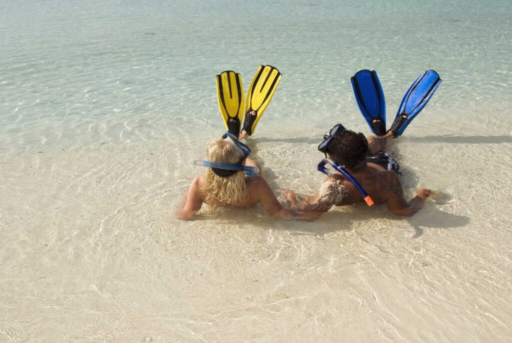 Honeymooners snorkeling together in the clear waters near Sabba Beach Hotels.