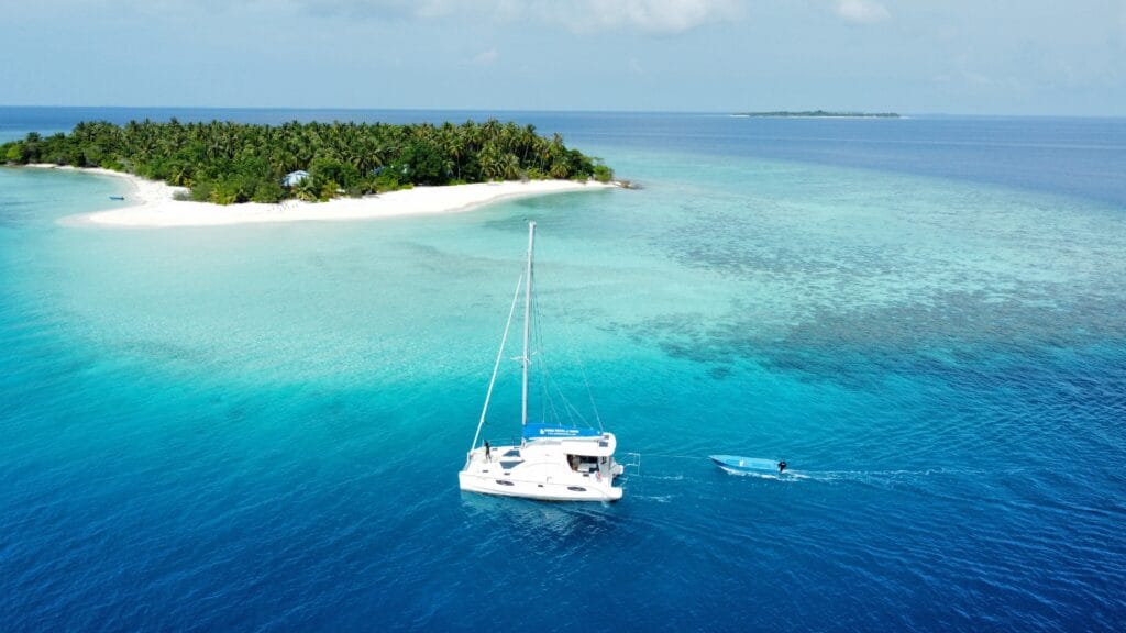 Catamaran cruising near an inhabited island close to Fodhdhoo Island.