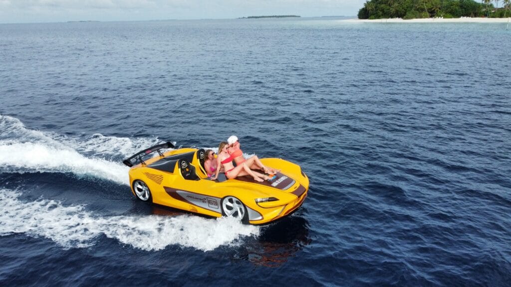 Three women riding a jetcar on the ocean at Fodhdhoo Island