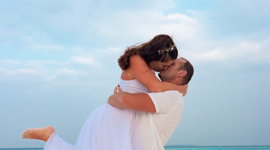 Loving couple sharing an intimate moment by the shore at sunset