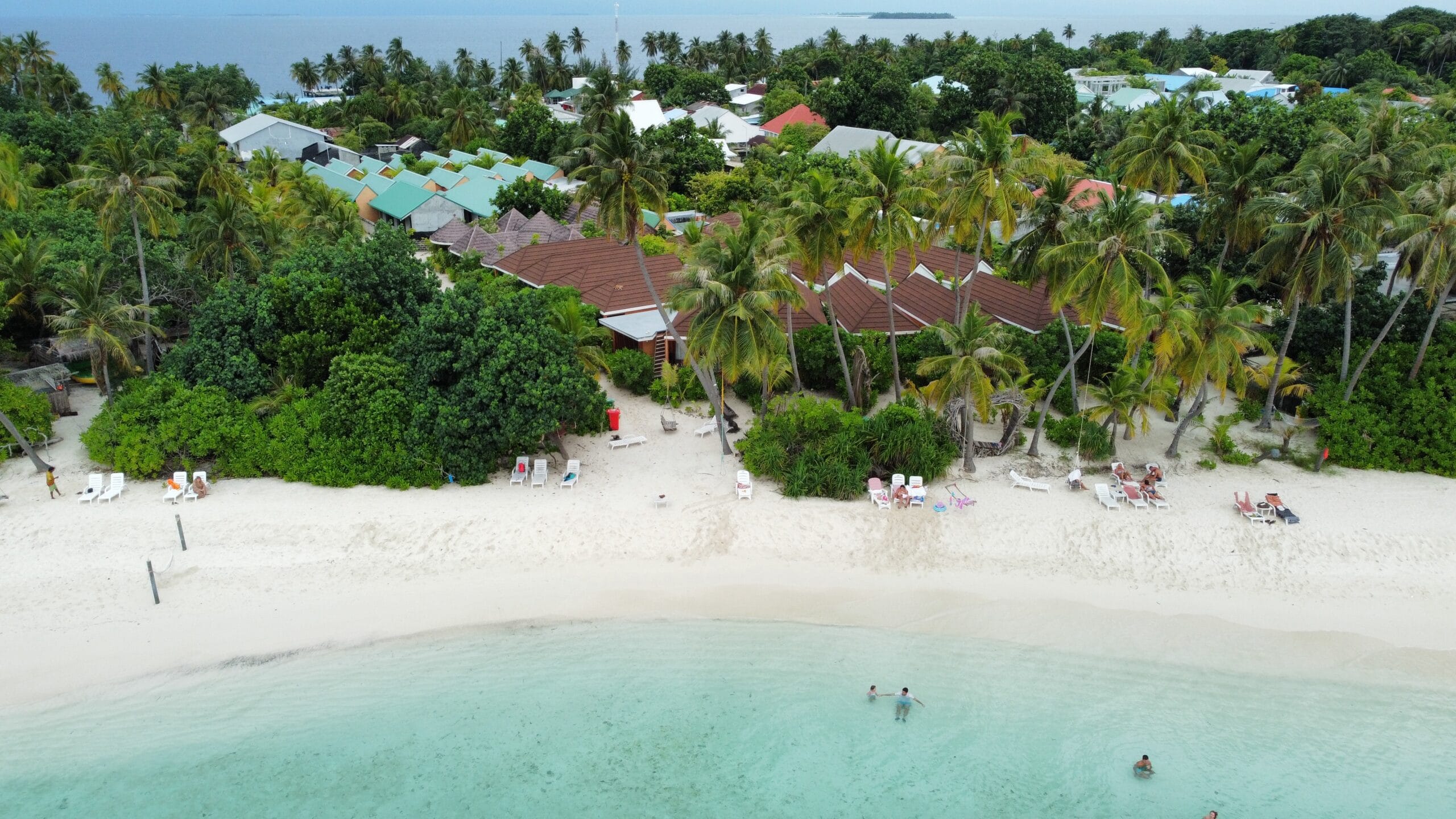 High-angle view of carefree beachgoers soaking up a lively Holiday at Maldives vibe