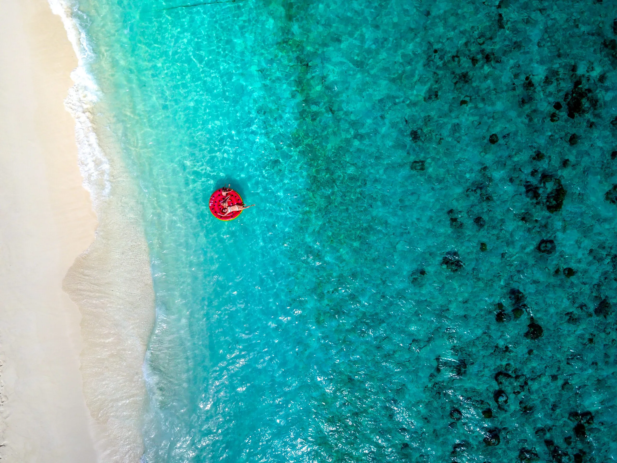 Mother and children laughing on a giant floaty in the warm lagoon during their Adventurous Holiday at Maldives