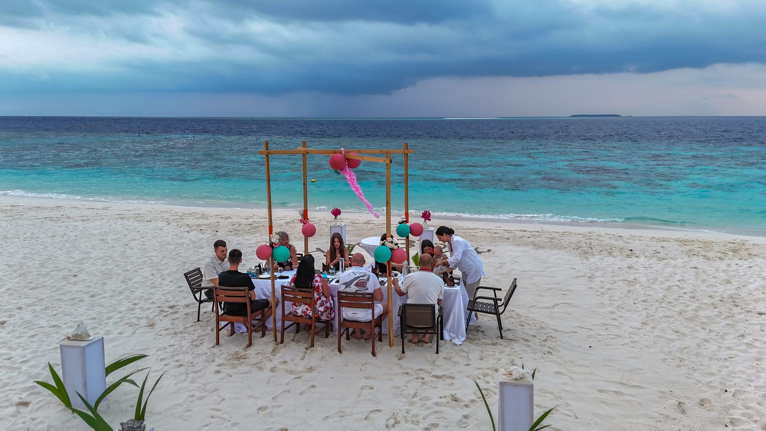 Joyful family celebrating a birthday with lantern-lit beach dinner on their Maldives For Families holiday