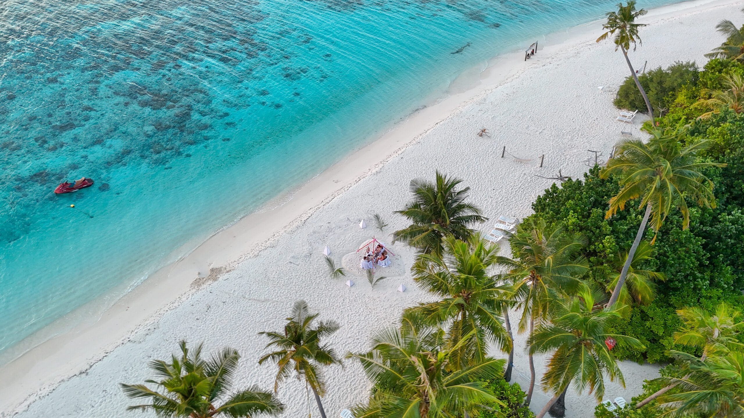 High-angle view of family enjoying sundown tea beside vivid lagoon on their Maldives For Families adventure