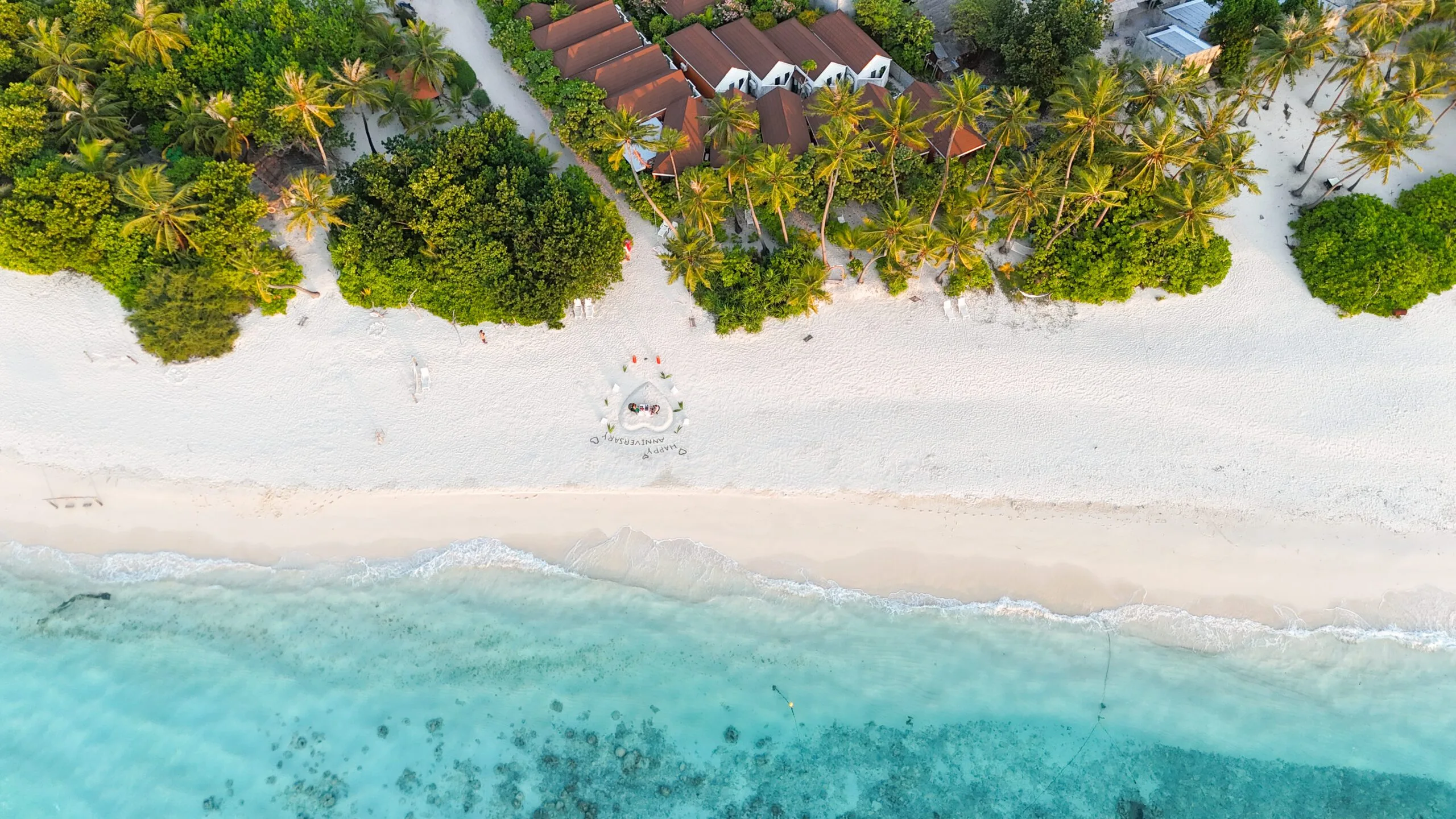 Drone panorama of Sabba Beach Hotels and pristine Bikini Beach bordered by bright coral shallows